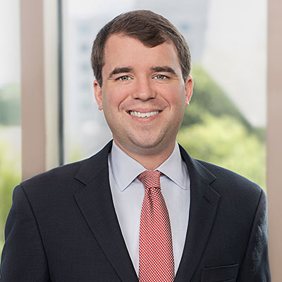 Paul Allen, Jr. wearing a dark suit and red tie