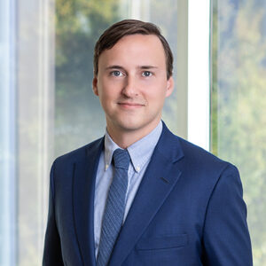 Michael Shirley wearing a navy suit and tie.